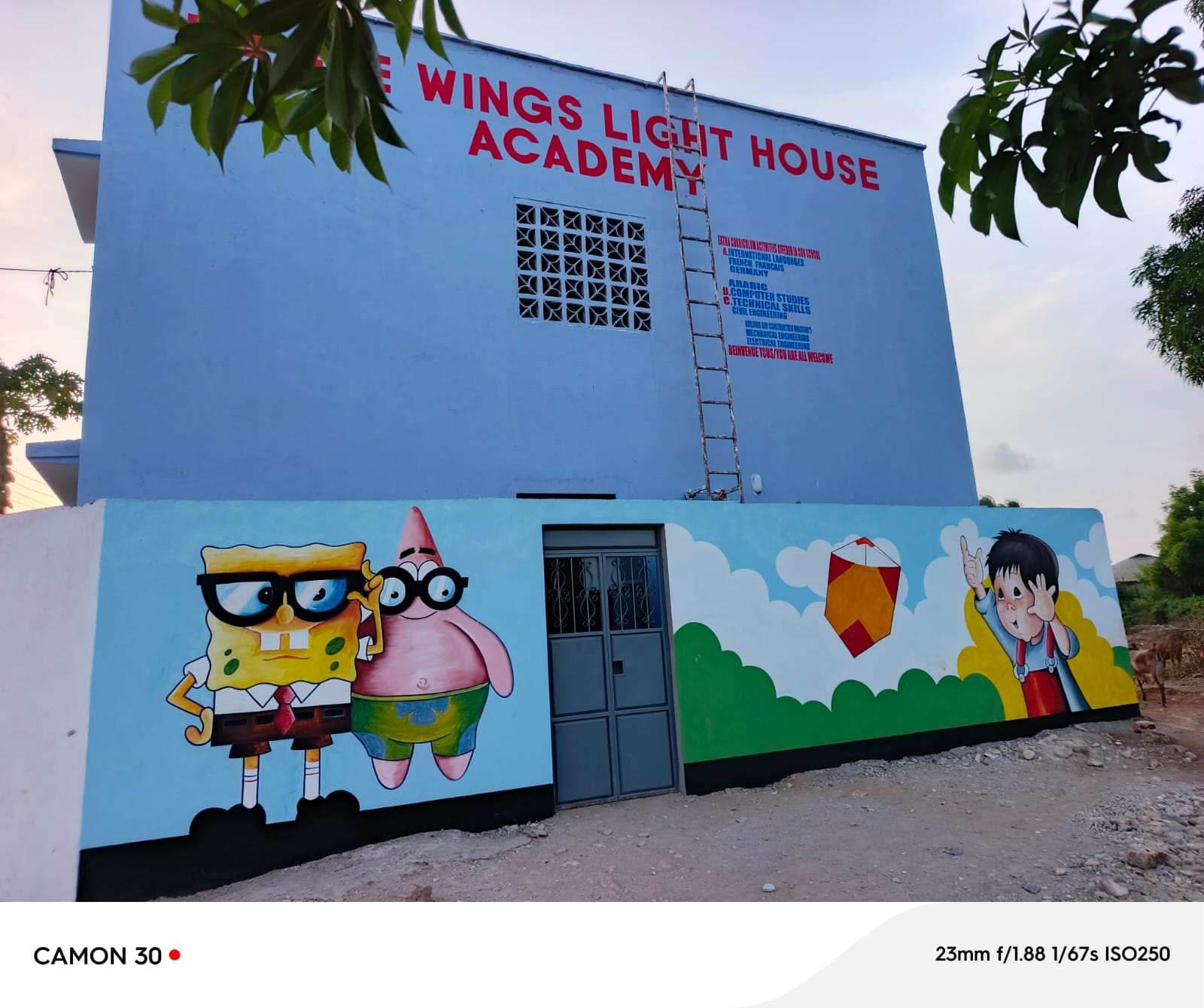 A playful Spongebob mural on the school building at sunset