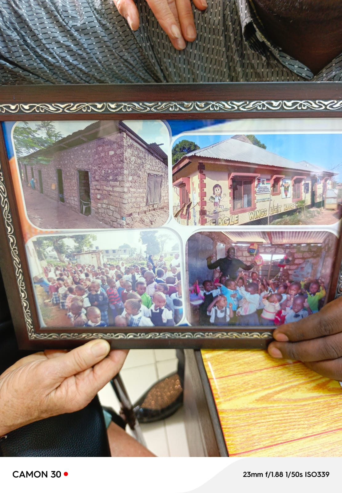 Director Johnstone Mdavan Maelo with learners holding a framed before and after collage of Eagle Wings Lighthouse Academy